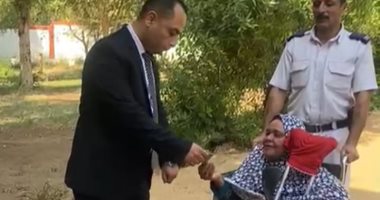 قاضٍ يساعد سيدة مسنة على الإدلاء بصوتها داخل لجنة كيما بأسوان